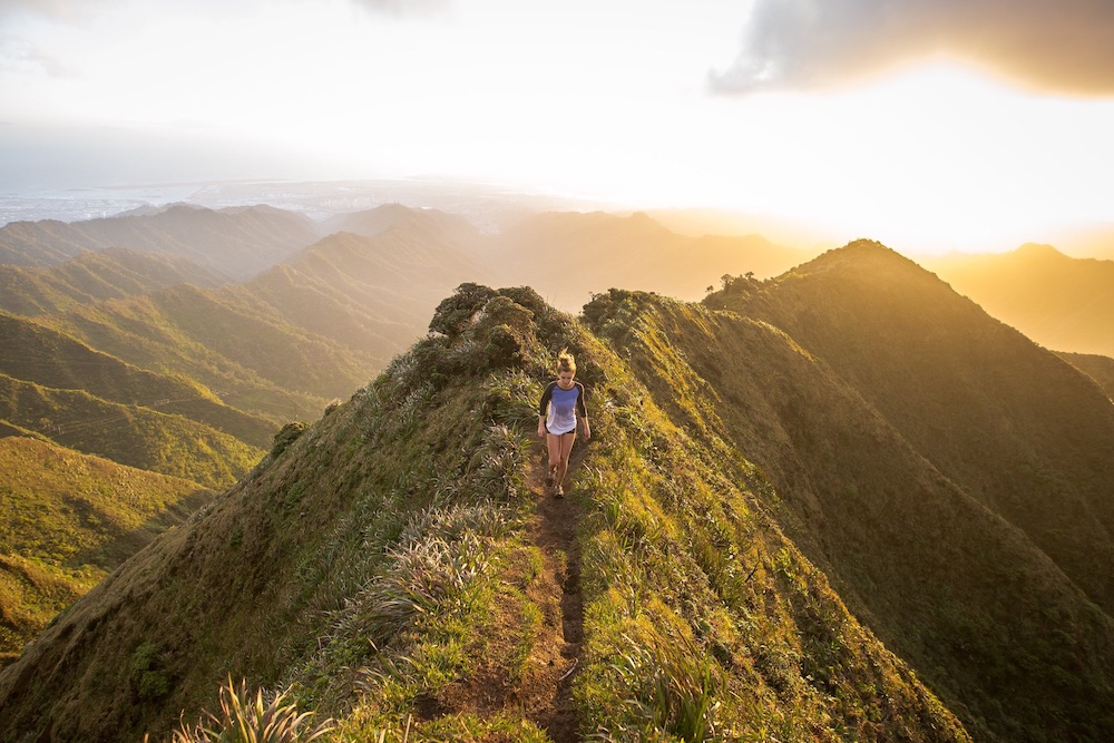 Person on a narrow trail on top of a mountain